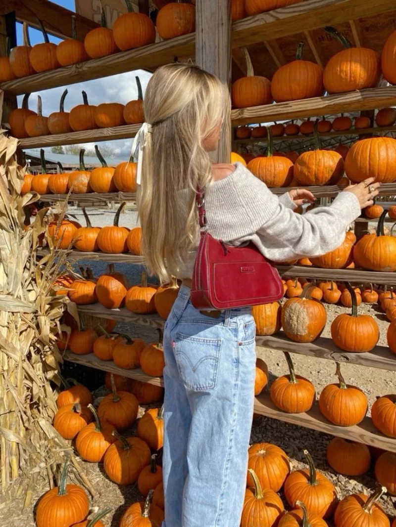 Off-The-Shoulder Cream Sweater + Light Wash Jeans + Red Shoulder Bag + White Hair Bow